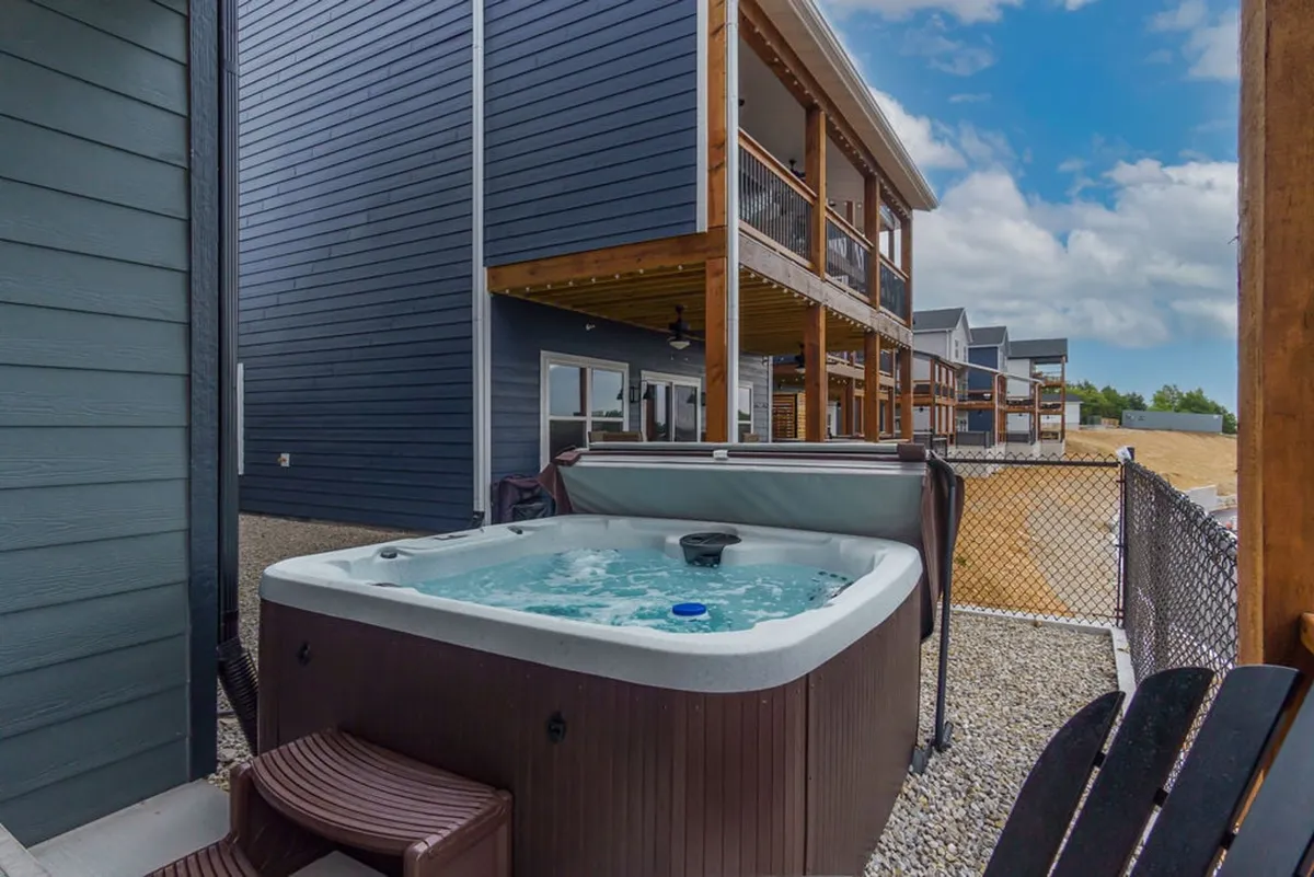 A serene hot tub is tucked next to outdoor seating, all overlooking sunset views beyond the property. The space is designed for relaxation and socializing, offering guests a tranquil spot to unwind under the stars or enjoy a morning soak with a view.