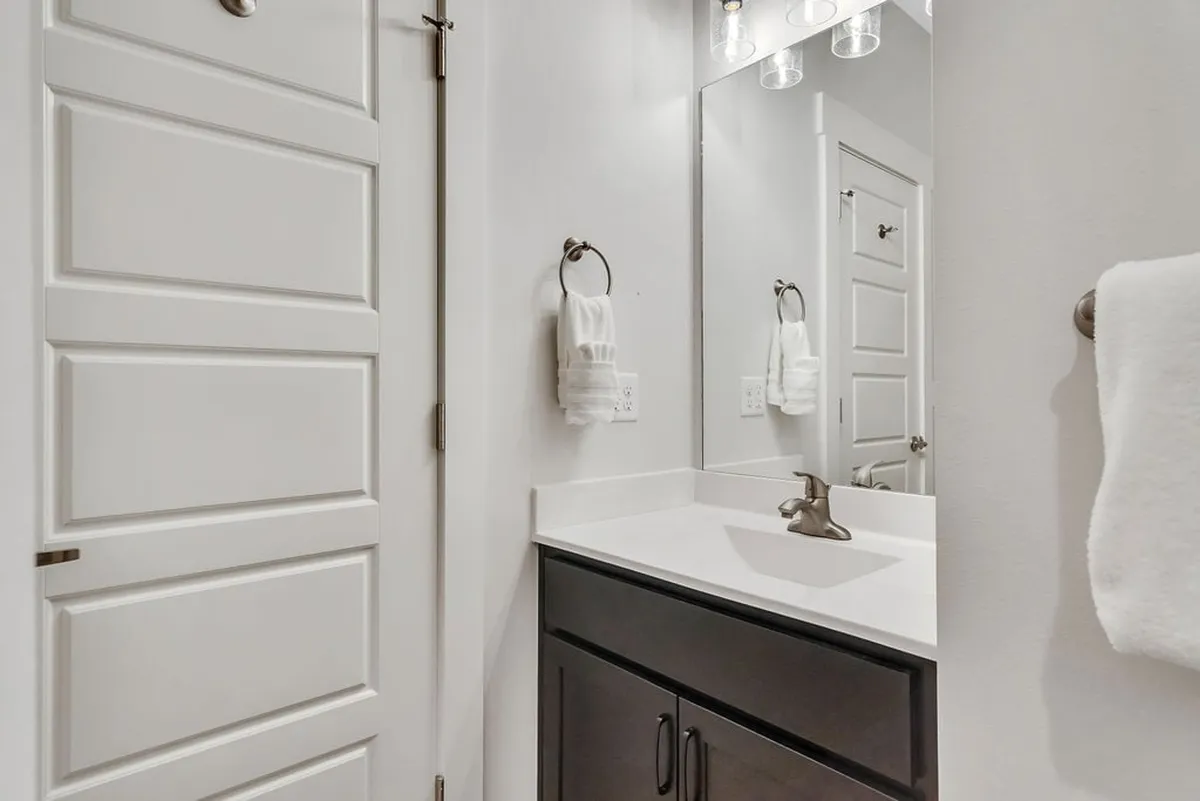 A modern bathroom with a sleek sink, mirror, and fresh towels. The calm ambiance and clean design echo a spa-like experience, offering a sensory hint of self-care and relaxation.